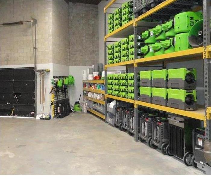 warehouse interior with green equipment loaded on shelves